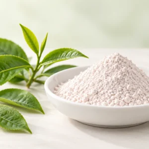Grayish-white Epigallocatechin Gallate powder beside fresh green tea leaves