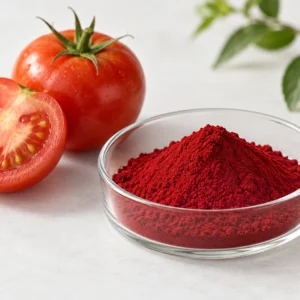 Deep red lycopene powder in a clear dish beside ripe whole and cut tomatoes
