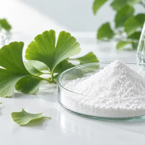 White Shikimic Acid powder in a clear dish with fresh Ginkgo biloba leaves
